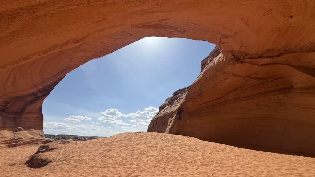 A view from inside a red rock cave looking out onto the sky. 
