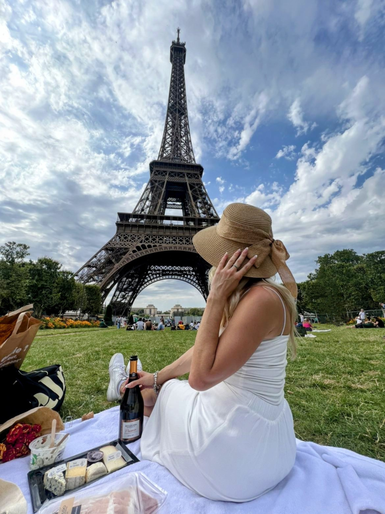 Woman having a picnic and looking at the Eiffel tower in Paris.