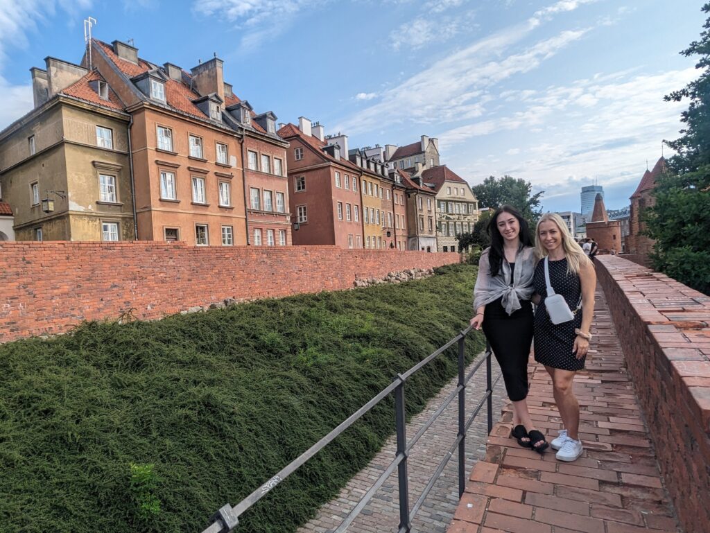 Mother and daughter standing on the walkway at the Barbakan wall in Warsaw Poland. Old Town is in the background.