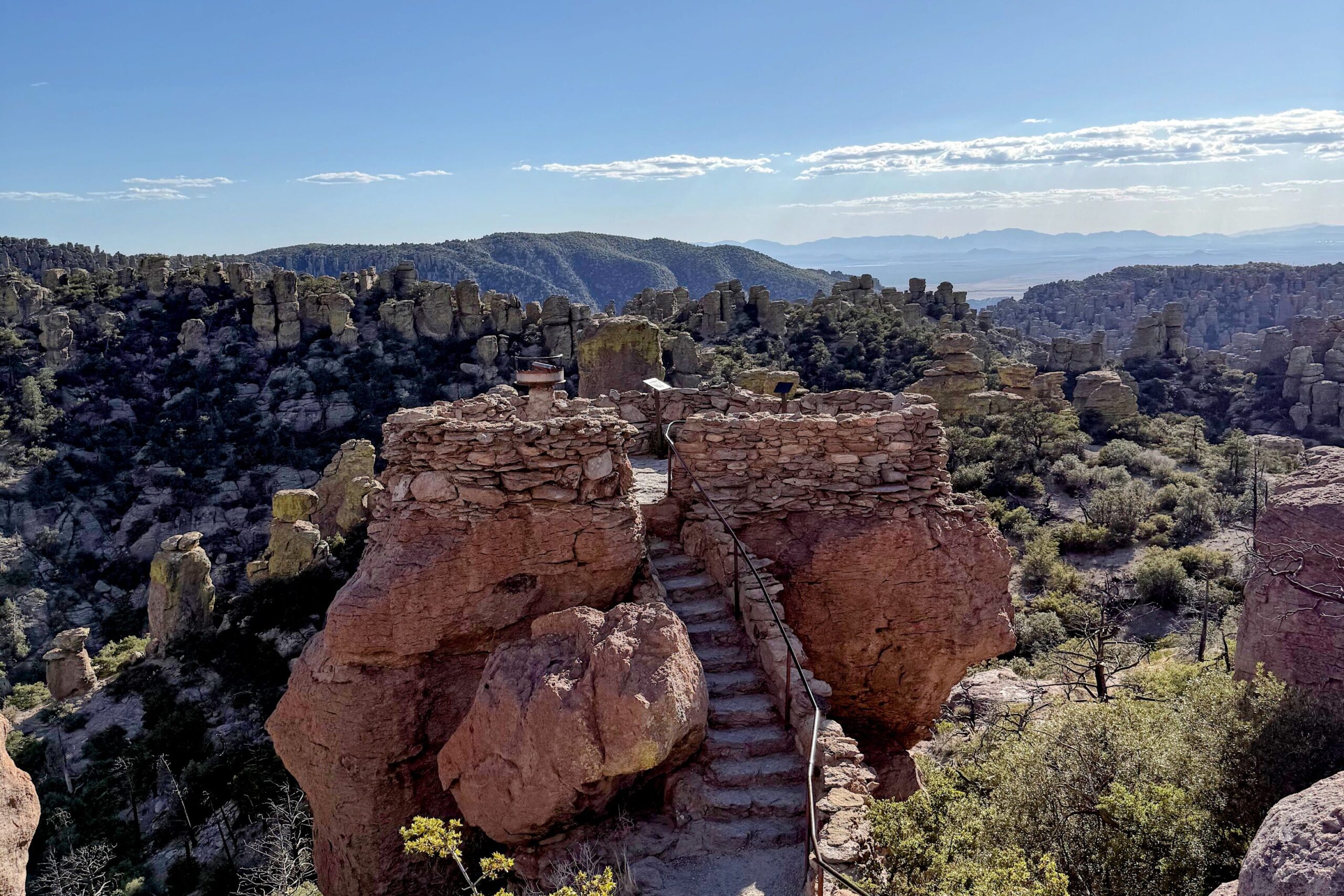View of hoodoos and rock formations around a rock platform with stairs.